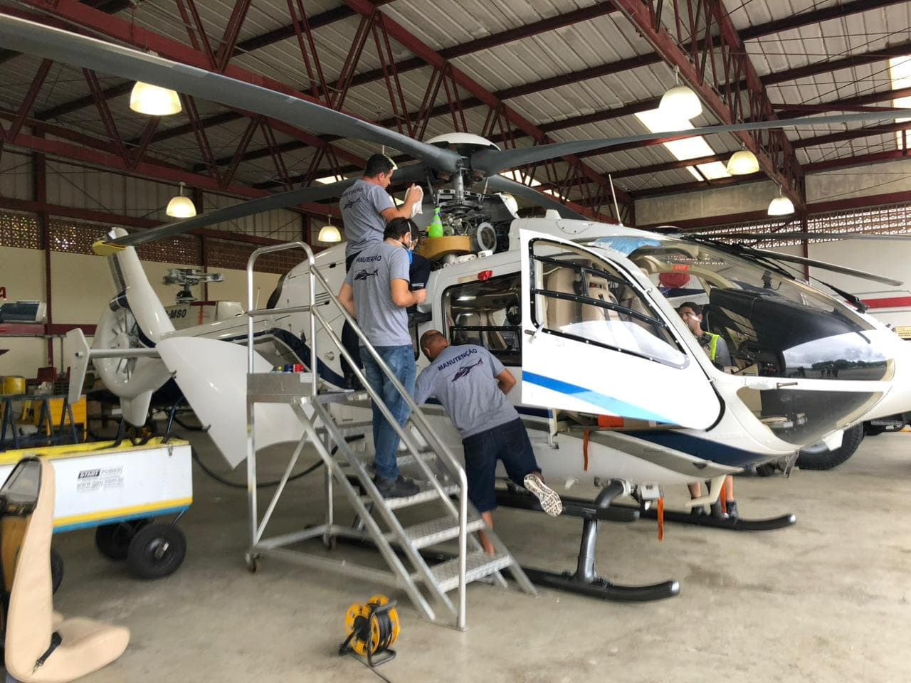 Helibarra mechanics working on helicopter rotor assembly